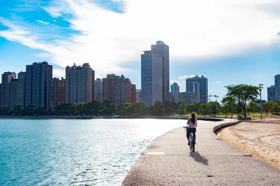 Cyclist riding along paved path at edge of Lake Michigan in Chicago, Illinois.
